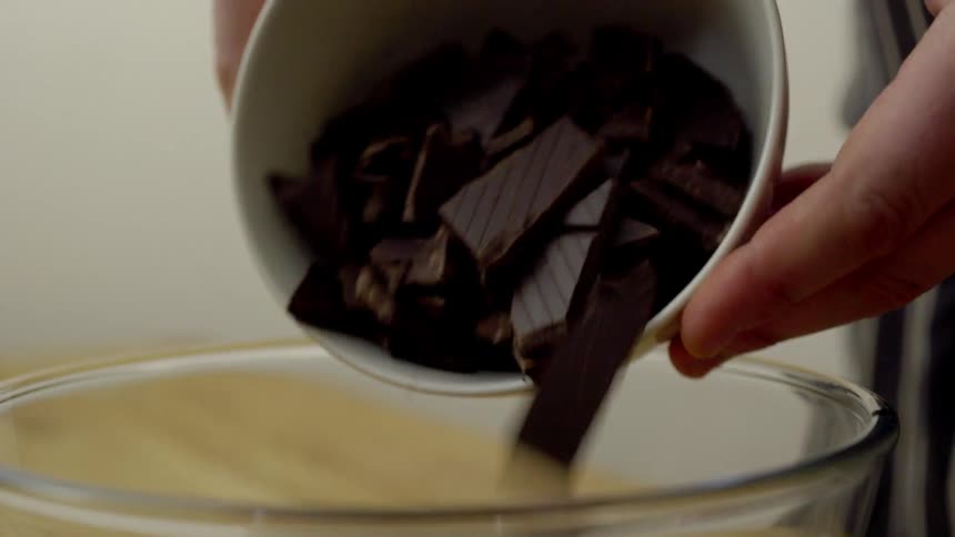 A person pouring chocolate into a bowl