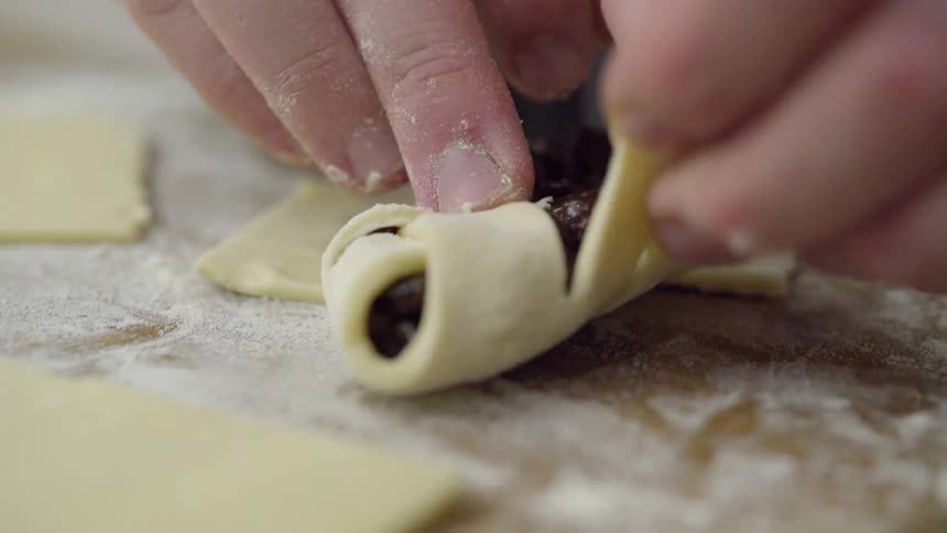 Someone is wrapping fruit up in a pastry