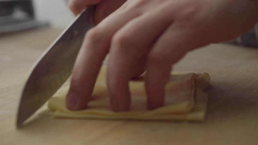 Pastry dough is being stacked and sliced