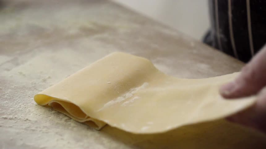 Someone flours a thin piece of dough