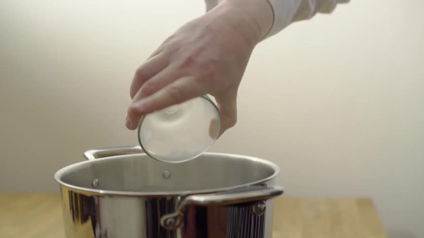 Salt is poured into a pot of boiling water