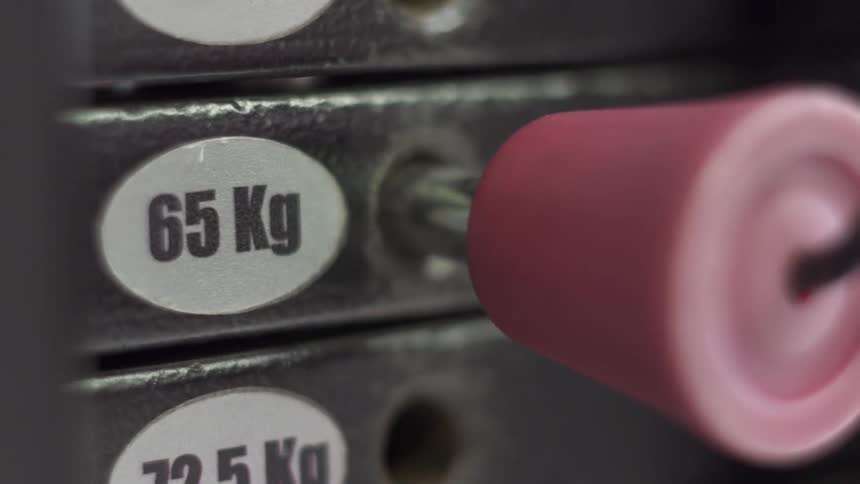 Person plugging pin into a weight