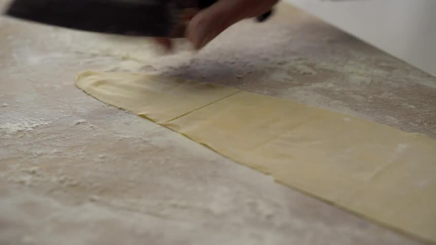 Man cutting some dough into squares