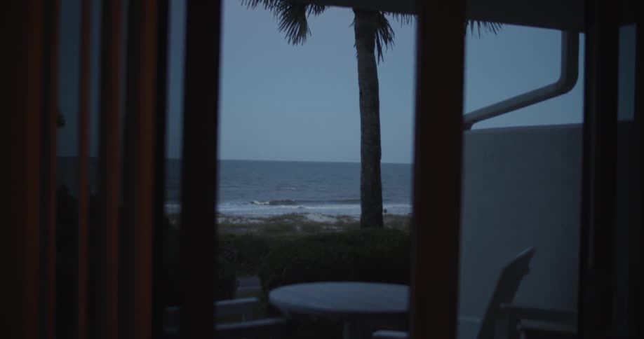 The waves crash against the shore outside of the home