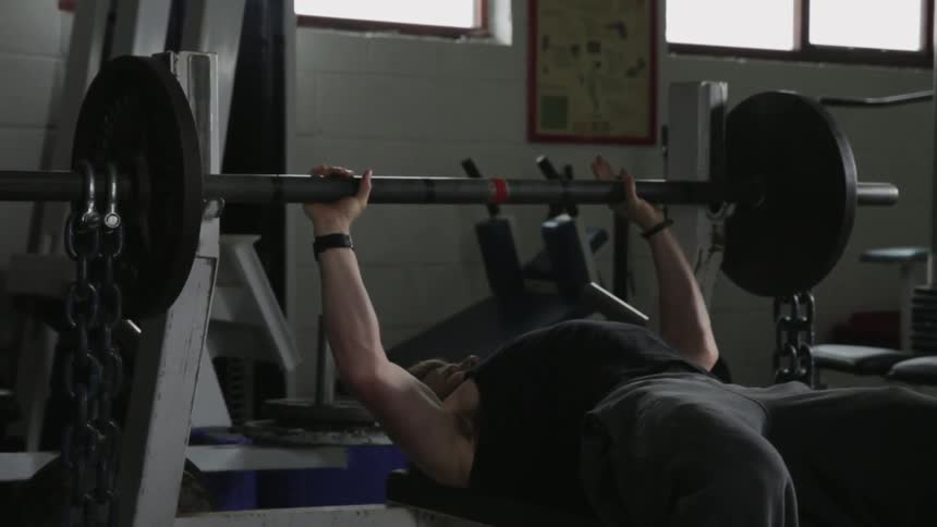 A man lifts weights at the gym