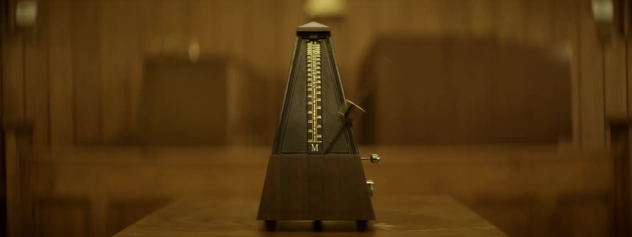 A metronome is ticking inside a building in daylight