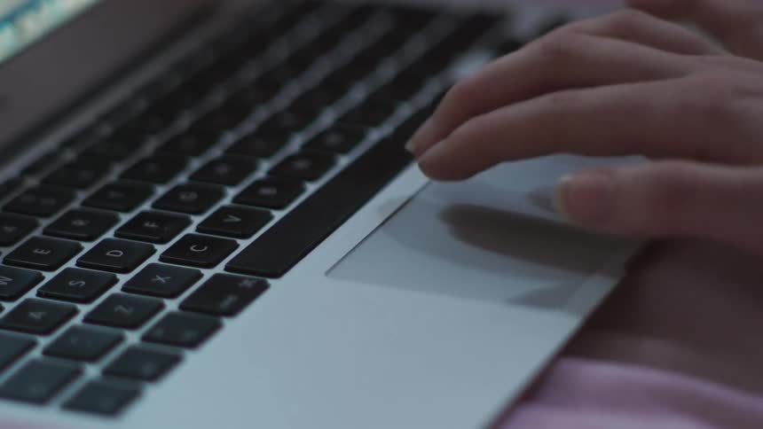 A woman using a touchpad on a laptop