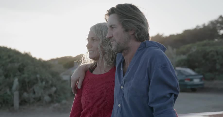A man and woman talk standing side by side