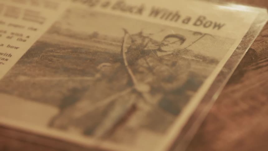 A newspaper clipping sits on a table