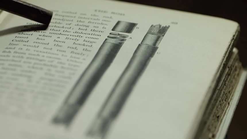 A metal bar is marking a page in an open book