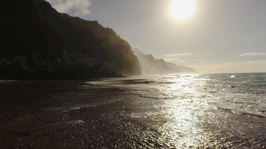 Sun shines over flowing water and a hilly shore