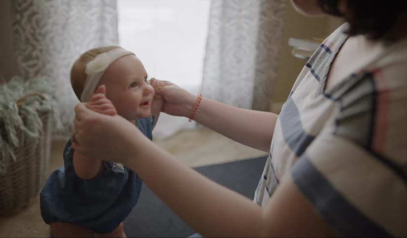 A woman talks to a smiling baby