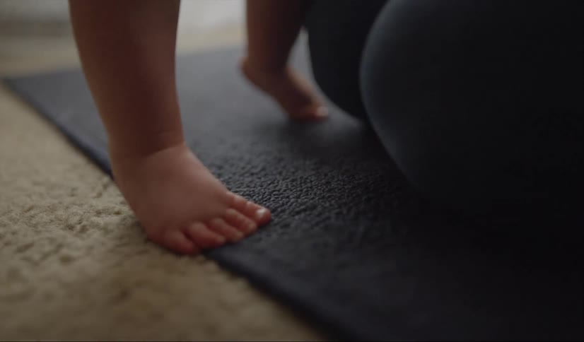 Adult plays with a baby on a rug