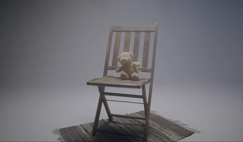 Teddy bear sitting in a wooden chair