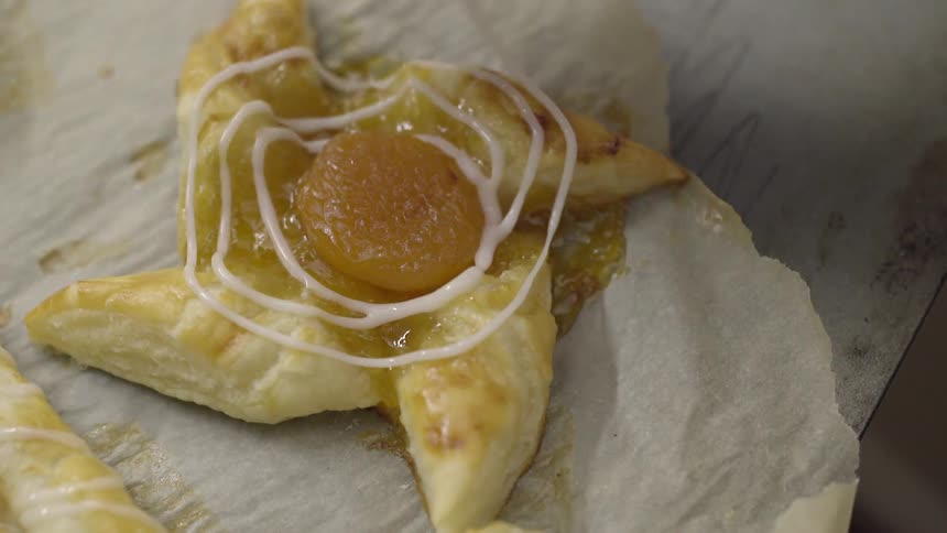 Person pours glaze over a pastry