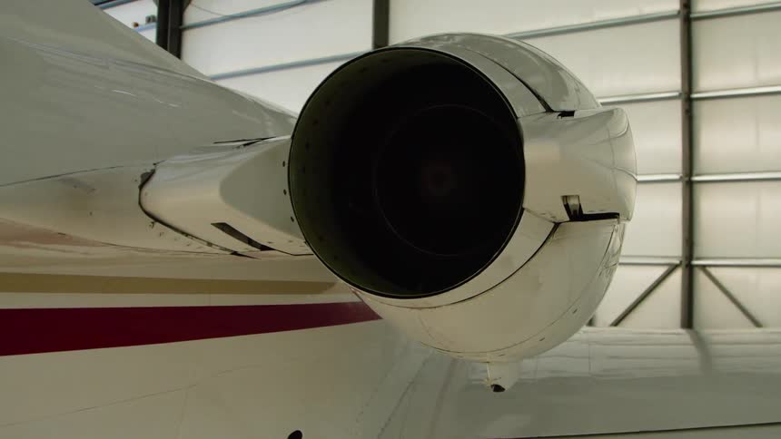The plane is parked near the wall in the hangar