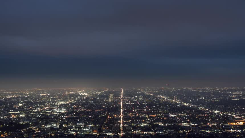 The city ahead is brightly lit on a cloudy night