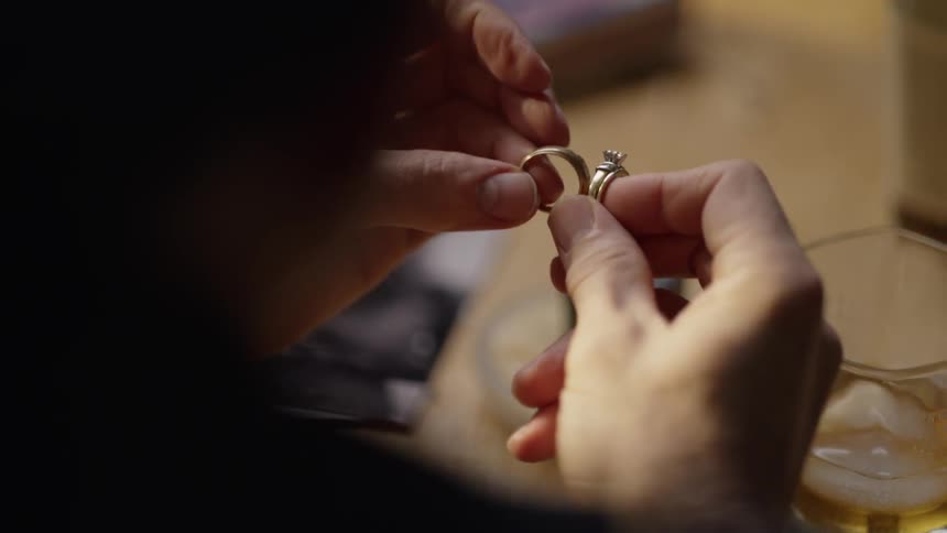 A man holds two gold rings in his hands