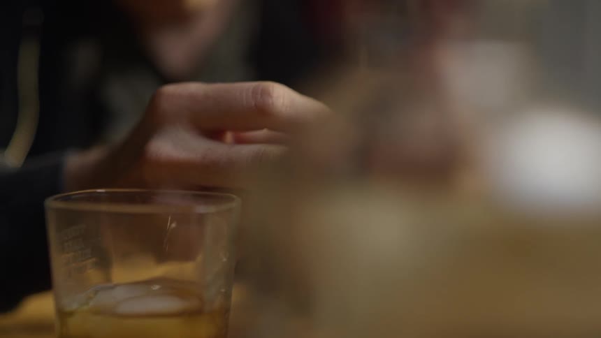 A man sits by a drink holding a ring