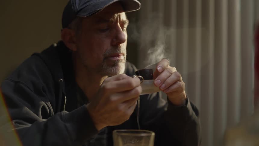 A man holds a ring as he blows a candle out