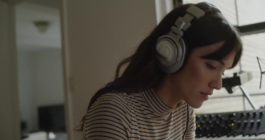 Woman wearing headphones in a house studio