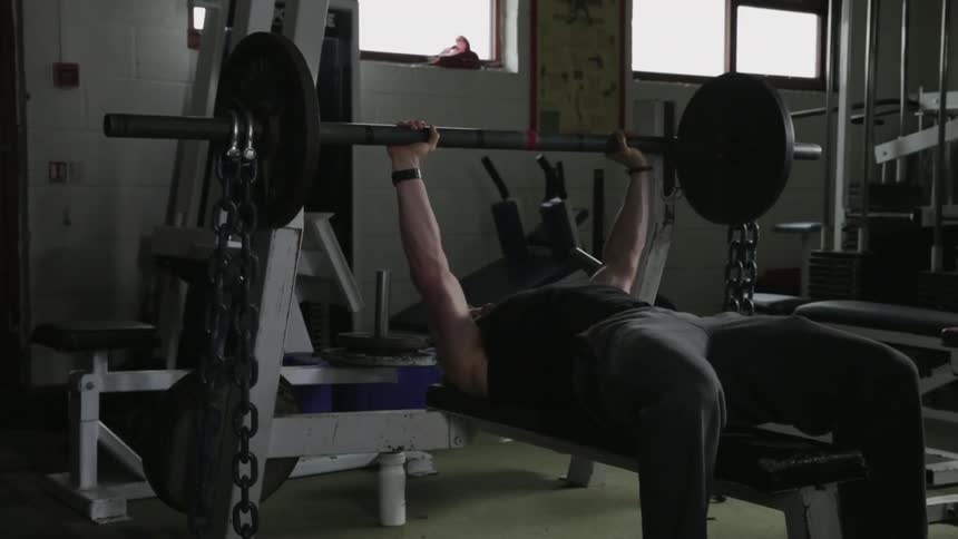 A man is lifting weights on a weight bench