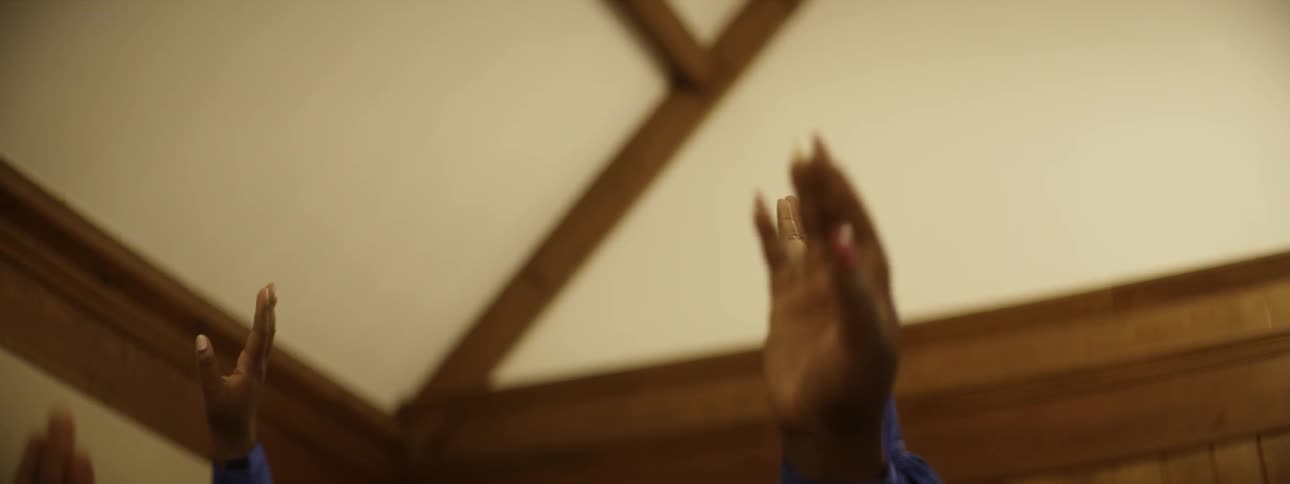 A church choir reach their arms up
