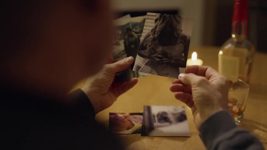 Person sitting at a table looking at photographs