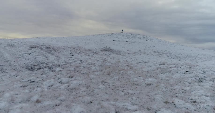 Person walks on snowy hilly plains