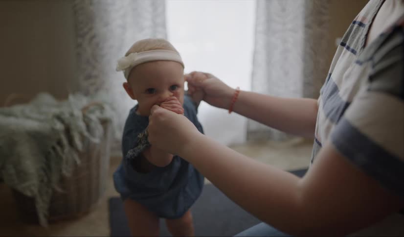 Adult holding a baby girl's arms
