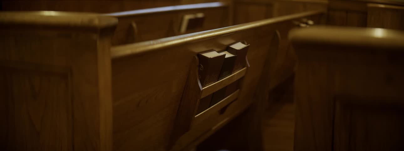 Bibles sit in a book holder on church benches