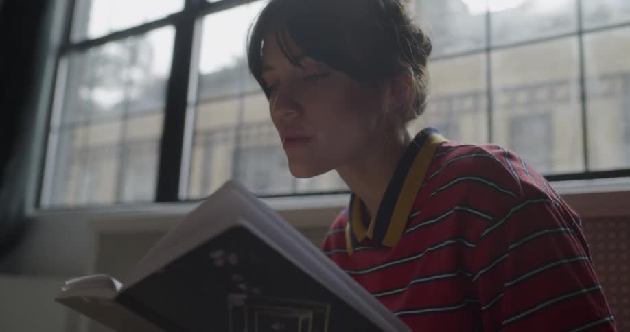 Woman eats with a spoon as she looks through a book