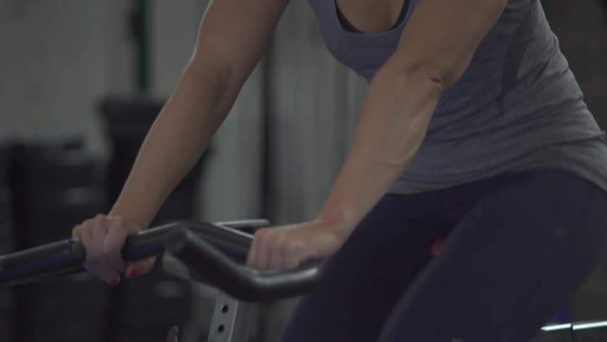 A woman rides an exercise bike