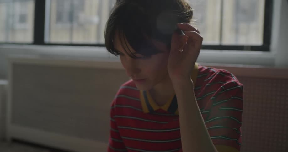 A woman looks down in the room smiling and writing