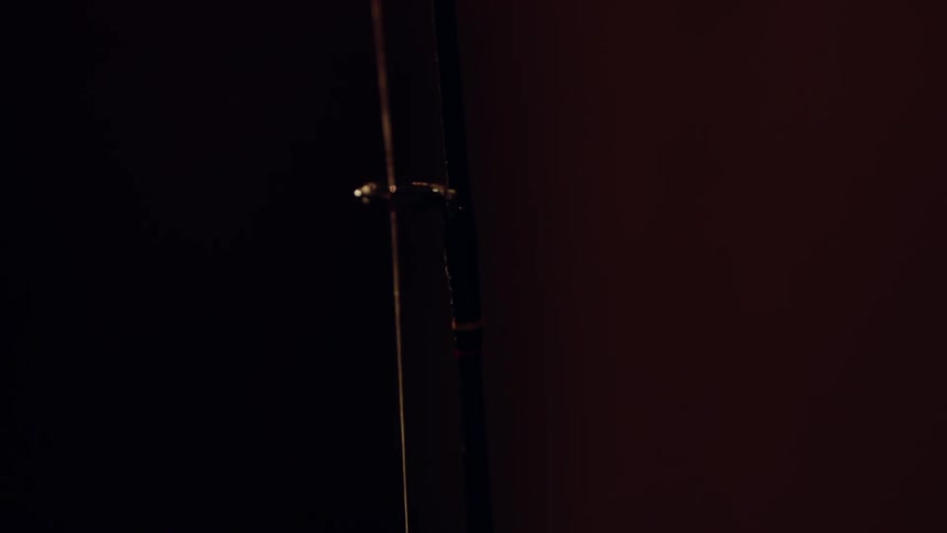 A fishing pole sits in the dark