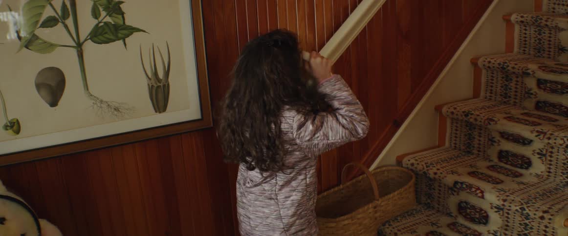 A young girl takes a hat out of a wicker basket