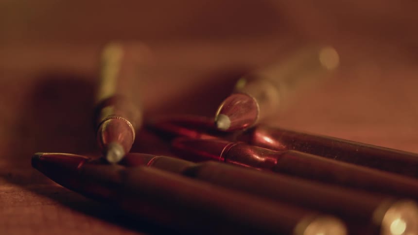 Bullets are lying in a pile on a table during the day