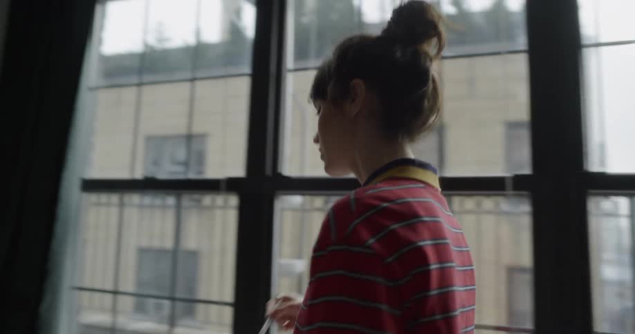 Woman writes in a notebook while pacing and talking to herself