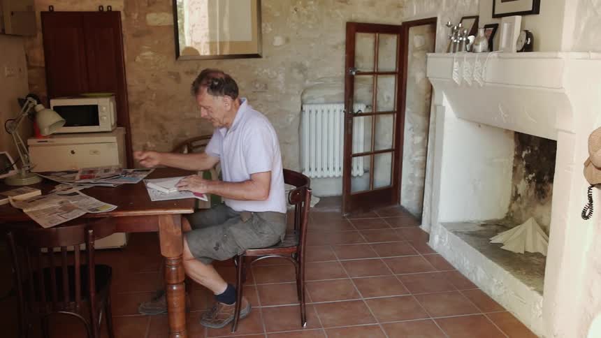 Man writes at a dining table