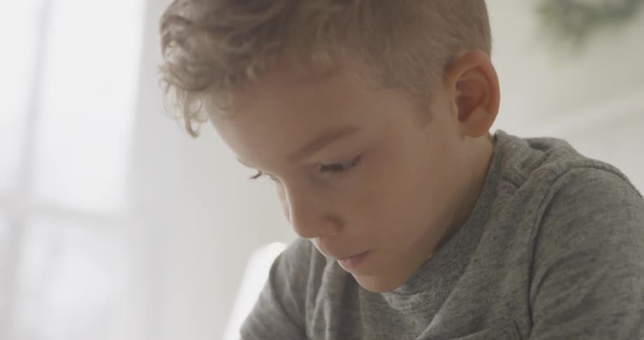 The boy looks down while he does something