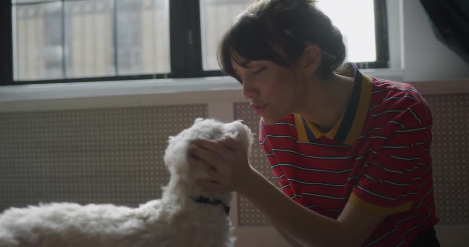 Woman pets and kisses a dog