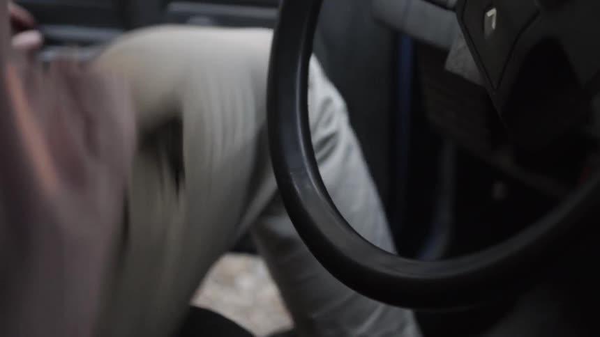 Man climbs into a car and takes off a wedding ring