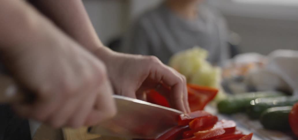 A person is cutting the peppers on the board