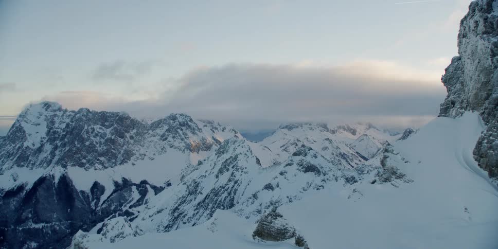 The peak of the mountain has heavy clouds above