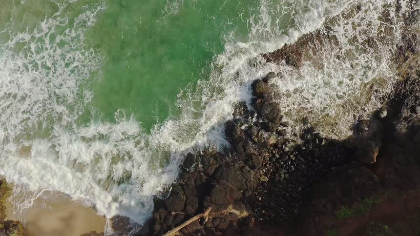The rough waves move towards the rocks