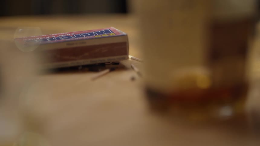 The matches are on the table near the bottle