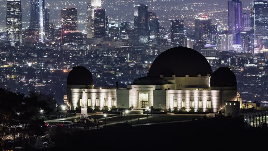 People walk around a monument at night