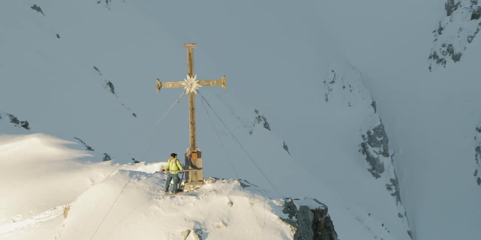 A large cross is on the edge of this mountain top