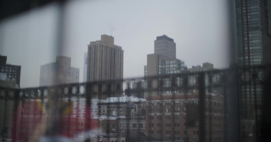 Woman paces in front of an apartment window