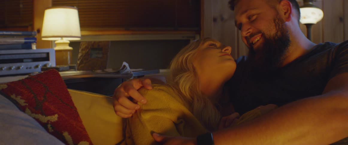 Man and woman are talking and embracing on couch